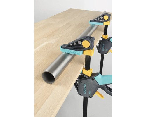 Obrábaný kus upevnený jednou rukou svorkami Wolfcraft a rúrkou