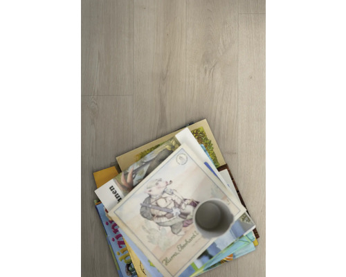 Hromada detských kníh a šálka na podlahe.