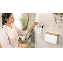 Kúpeľňová scéna s kozmetickým boxom, štetcami na líčenie a ženou