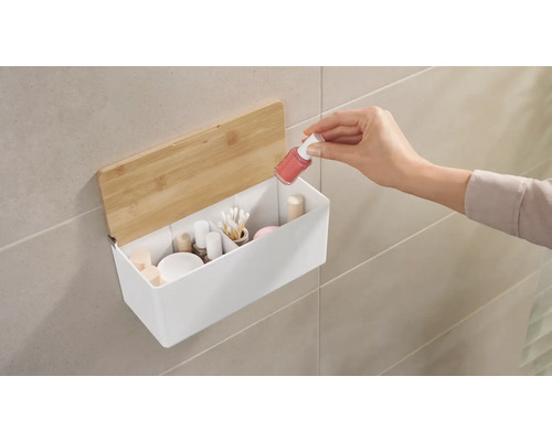 Nástenný úložný box s kozmetikou a rukou, ktorá do neho vkladá lak na nechty