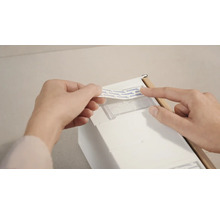 Pripevnenie lepiaceho prúžku na kúpeľňový doplnok.