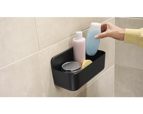 Čierny sprchový košík s kozmetikou na stene