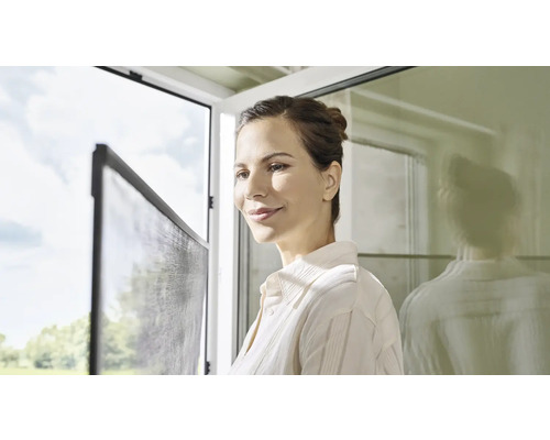 Žena sa pozerá na sieť proti hmyzu na okne