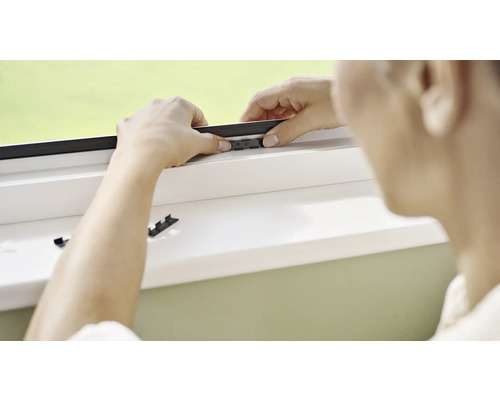 Osoba montuje sieť proti hmyzu na okno