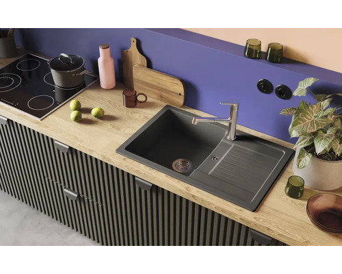 Kuchynský drez s odkvapkávacou plochou, batériou a varnou doskou v modernom kuchynskom prostredí