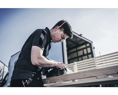 Remeselník hobľuje drevo elektrickým hoblíkom vonku