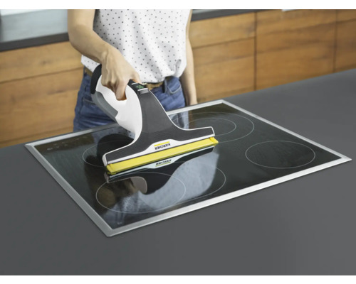 Žena čistí sklokeramickú varnú dosku pomocou okenného vysávača