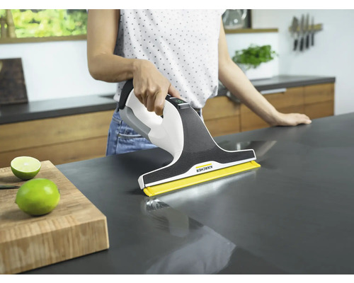 Žena čistí pracovnú dosku pomocou čističa okien Kärcher