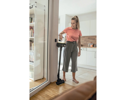 Žena používa akumulátorový vysávač v obývacej izbe