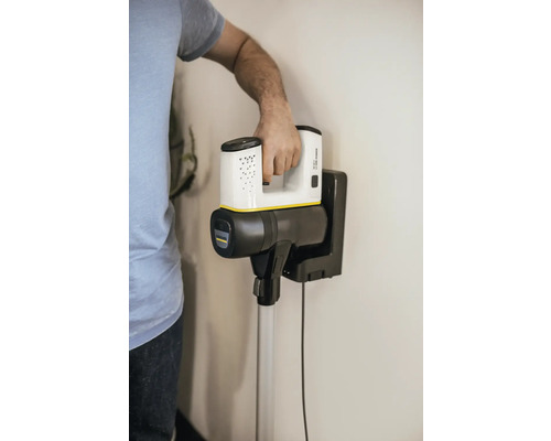 Akumulátorový vysávač na nástennom držiaku s osobou