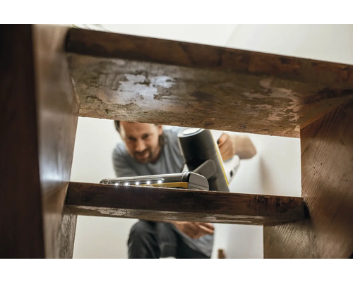 Muž čistí schody pomocou akumulátorového vysávača s LED osvetlením