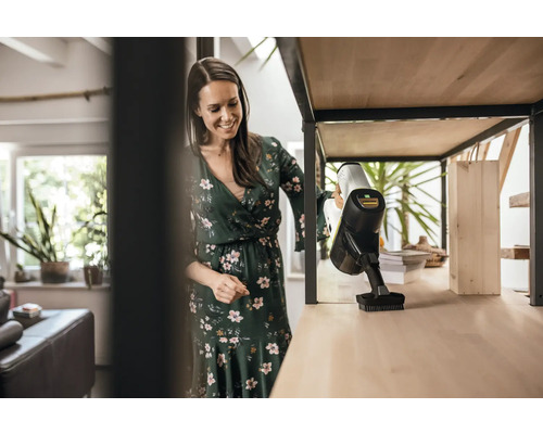 Žena čistí policu pomocou akumulátorového vysávača