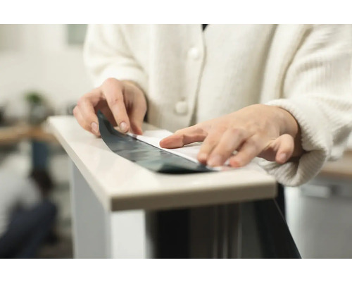 Osoba nanáša fóliu na povrch.