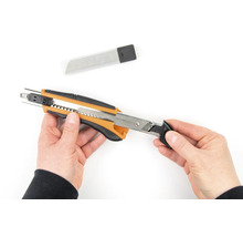 Ruky držia rezací nôž s náhradnými čepeľami