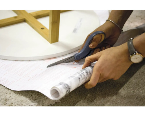 Strihanie dekoračnej fólie nožnicami na stôl