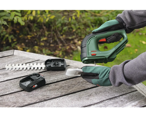 Akumulátorové nožnice s akumulátorom, nožom a príslušenstvom na drevenom stole