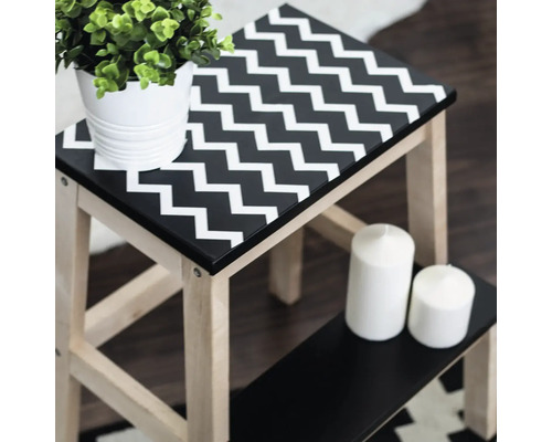 Drevená stolička s cikcakovým vzorom, rastlina a sviečky