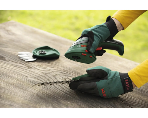 Akumulátorové nožnice s nadstavcom na trávu a kríky značky Bosch na drevenom stole