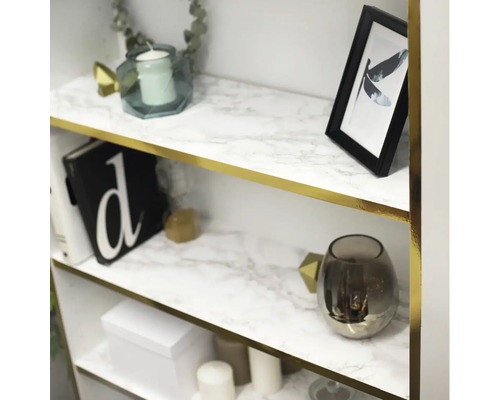 Polica s dekoračnou fóliou s mramorovým vzhľadom, zdobená dekoratívnymi predmetmi, ako sú sviečky a fotorámčeky.