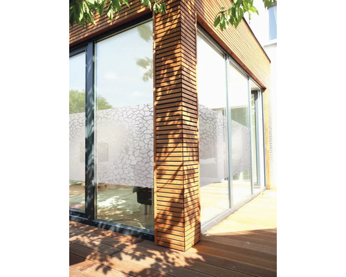 Exteriér moderného domu s dreveným obkladom a veľkými oknami so súkromnou fóliou.