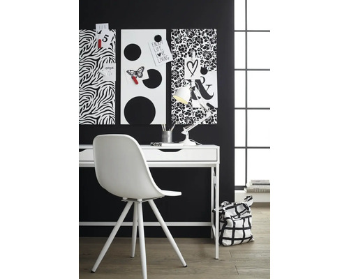 Písací stôl s nástenkami, stolnou lampou a stoličkou v pracovni.