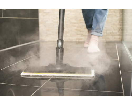 Parný čistič v prevádzke na dlaždicovej podlahe v kúpeľni