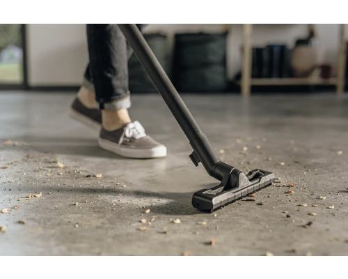 Osoba používa vysávač na čistenie podlahy.
