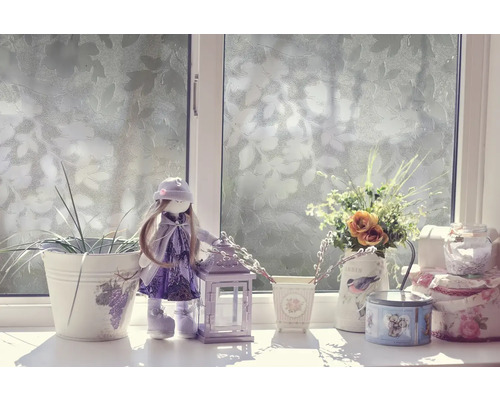 Dekoratívna scéna na okennom parapete s bábikou, lampášom a kvetmi vo vázach