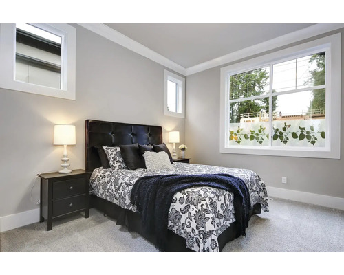 Spálňa s posteľou, nočnými stolíkmi a oknom s dekoratívnou fóliou