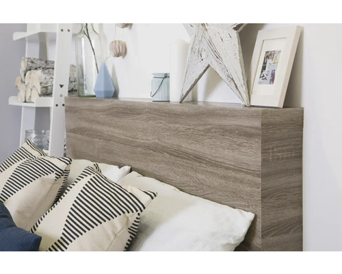 Posteľ s dreveným čelom a poličkou s dekoráciami