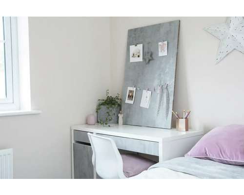 Písací stôl s magnetickou tabuľou, stoličkou a dekoráciou vo svetlej izbe.