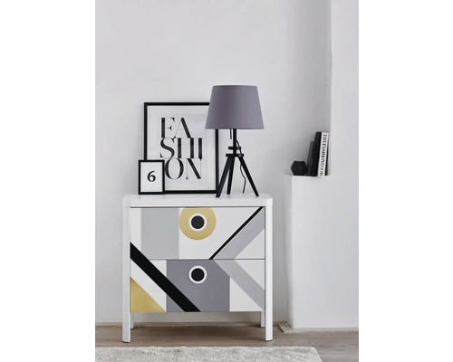 Komoda s geometrickým vzorom, stolná lampa a dekoratívne prvky