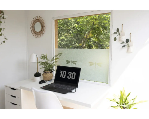 Svetlá pracovná oblasť so stolom, notebookom a okennou fóliou s motívmi vážok