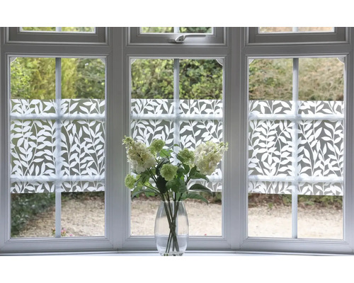 Okno s dekoratívnou okennou fóliou a kyticou kvetov vo váze