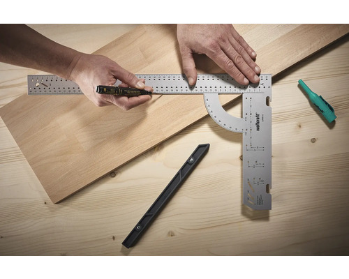 Osoba označuje drevenú dosku značkou a uholníkom.