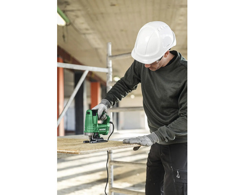 Muž s ochrannou helmou reže drevo priamočiarou pílou značky HiKOKI.