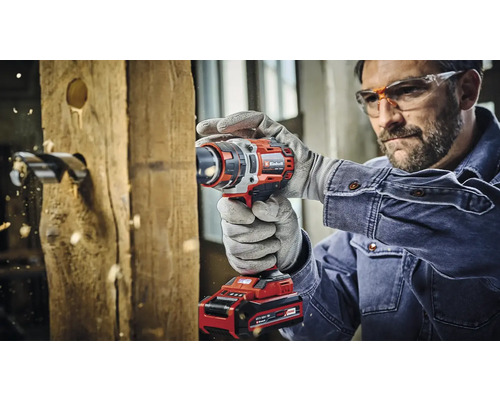 Muž vŕta otvor do drevenej dosky pomocou akumulátorového vŕtacieho skrutkovača.