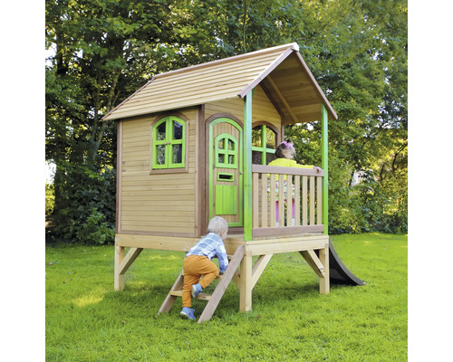 Drevený domček na hranie so šmýkačkou v záhrade s hrajúcimi sa deťmi