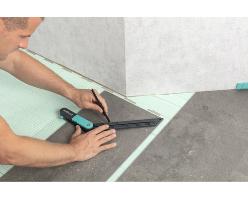 Remeselník označuje dlaždicu ceruzkou a uholníkom