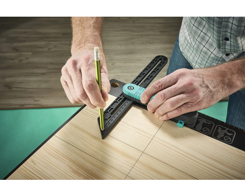 Osoba používa uholník a ceruzku na nakreslenie čiar na drevenej doske.