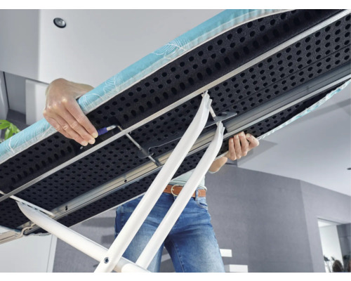 Osoba nesie žehliacu dosku s podstavcom