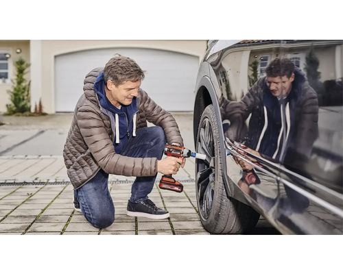 Muž mení koleso na aute pomocou akumulátorového rázového uťahovača