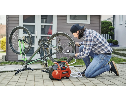 Muž hustí pneumatiku bicykla kompresorom
