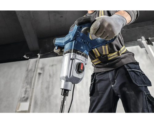 Stavebný robotník obsluhuje demolačné kladivo.