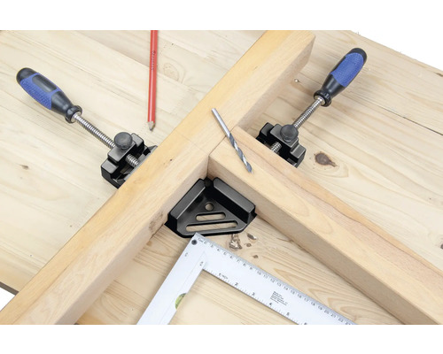 Pracovný stôl s drevom, skrutkovacie zveráky, uholník a vrták