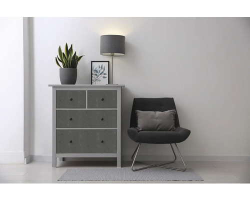 Obývacia izba s komodou, kreslom, lampou a izbovou rastlinou pre štýlové zariadenie