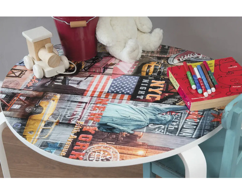 Detský stôl s motívom New Yorku, ležia na ňom hračky, ceruzky a kniha