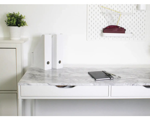 Pracovňa s pracovným stolom v mramorovom vzhľade, zápisníkom a úložnými priehradkami