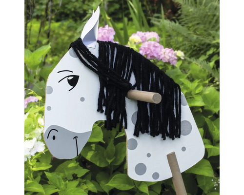 Drevený hojdací kôň s hrivou z priadze v záhrade