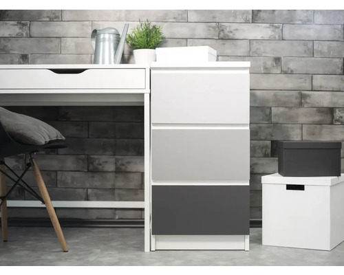 Scéna so stolom, zásuvkovým dielom a úložnými boxmi pred tehlovou stenou